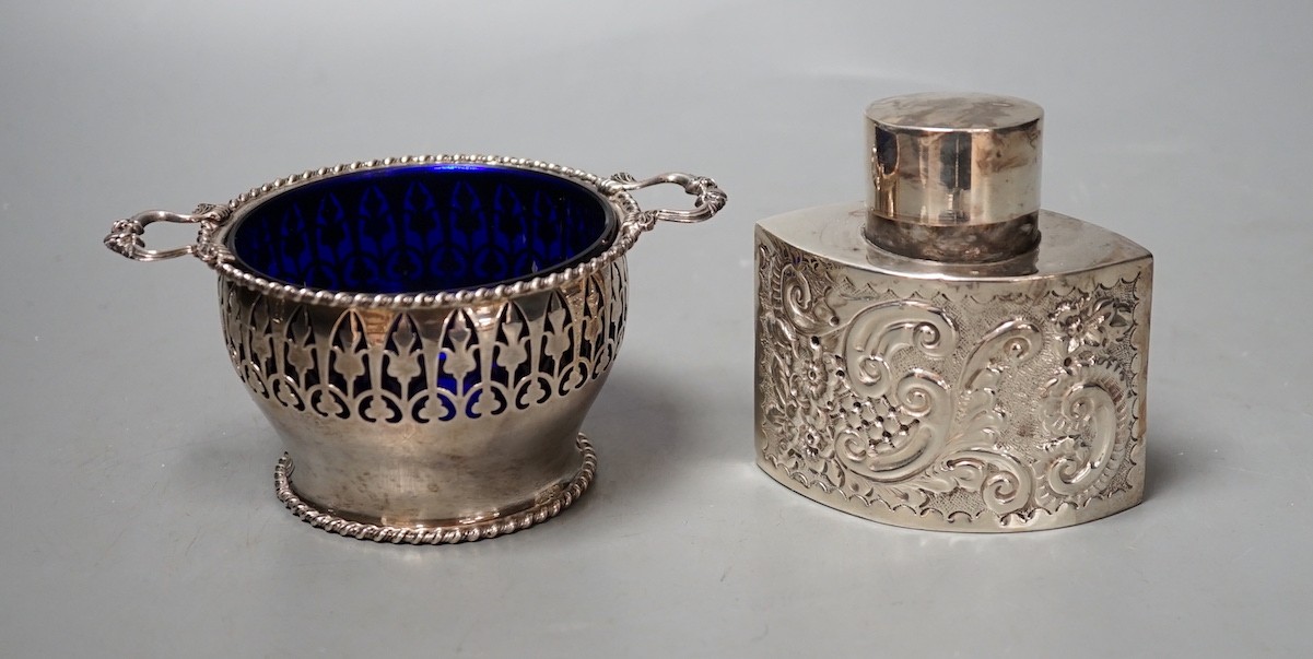 A late Victorian repousse silver tea caddy, Birmingham, 1899, height, 86mm and a later silver two handled sugar bowl with blue glass liner.